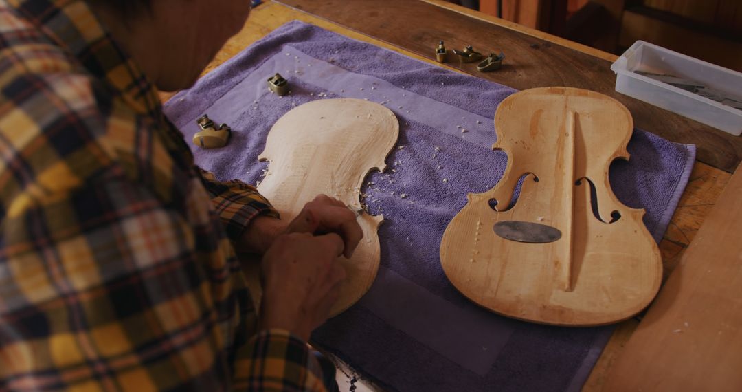 Senior Female Luthier Crafting Violin Body with Precision Chisel Work