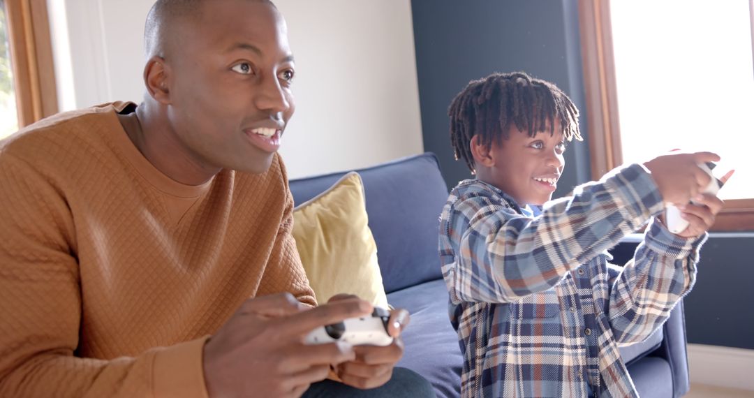 Father and Son Enjoying Video Games on Couch at Home - Free Images, Stock Photos and Pictures on Pikwizard.com