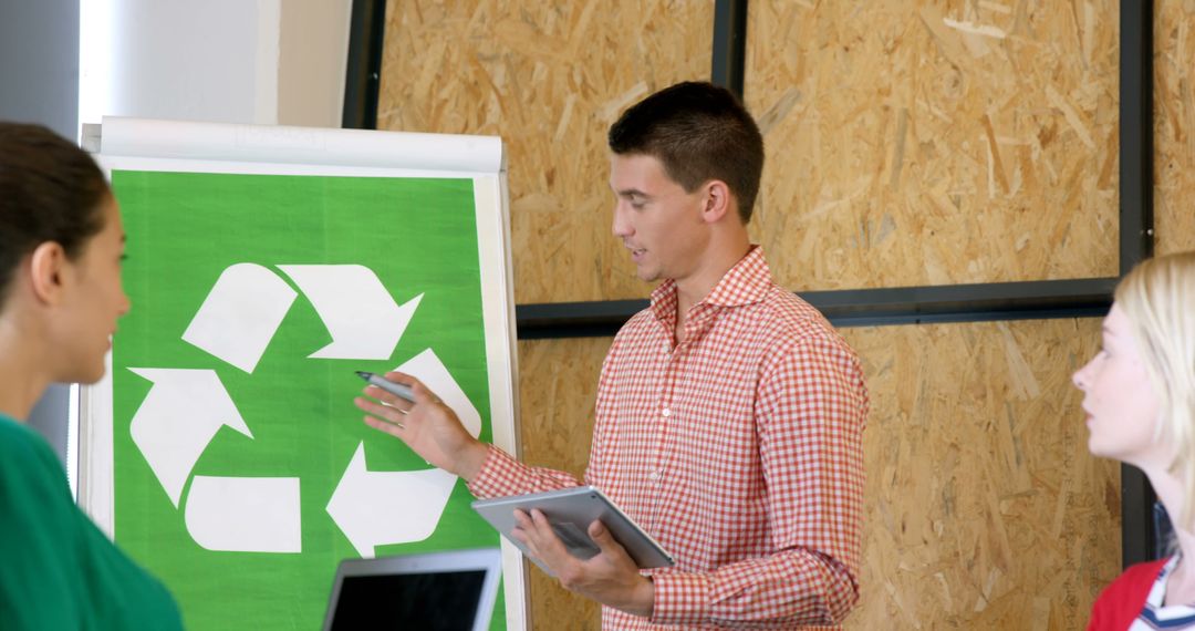 A young Caucasian businessman is presenting a recycling concept to colleagues, with copy space - Free Images, Stock Photos and Pictures on Pikwizard.com