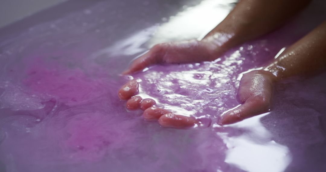 Relaxing Aromatherapy Bath with Purple Water and Hands Submerged - Free Images, Stock Photos and Pictures on Pikwizard.com