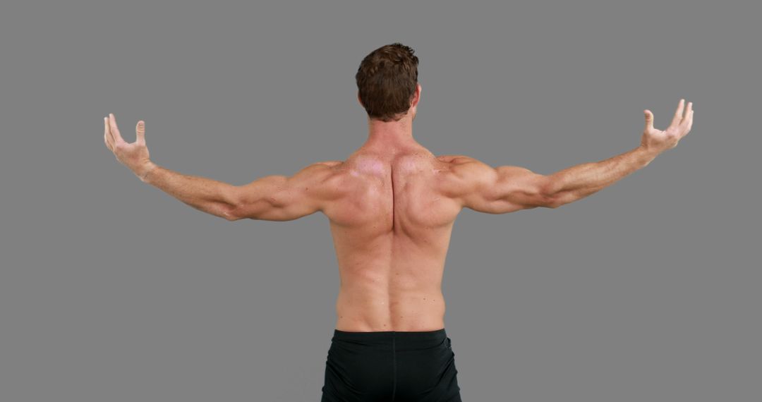 A muscular Caucasian man poses to emphasize his strong back and arms for fitness content. - Free Images, Stock Photos and Pictures on Pikwizard.com