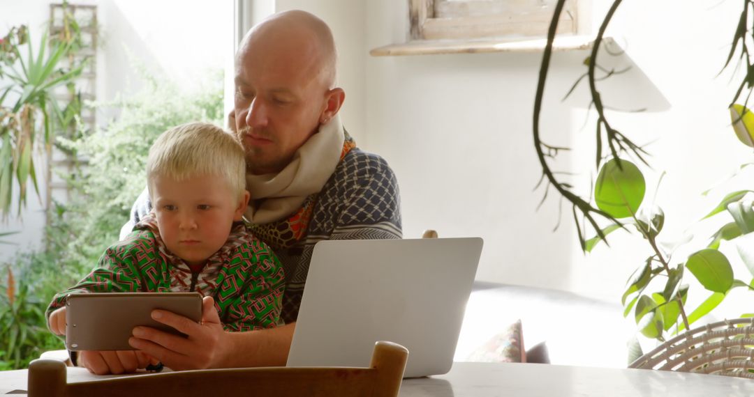 Father and Son Using Tablet Together at Home Garden