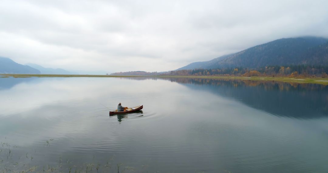 Solitary Fishing Boat on Tranquil Lake During Misty Autumn Day - Free Images, Stock Photos and Pictures on Pikwizard.com