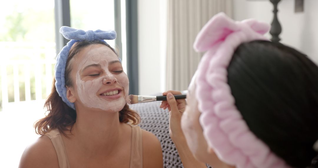 Two Friends Enjoying Spa Day with Facial Masks at Home