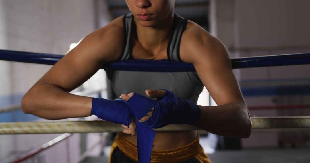 Female Boxer Wrapping Hands with Blue Wrist Wraps in Training Ground - Free Images, Stock Photos and Pictures on Pikwizard.com