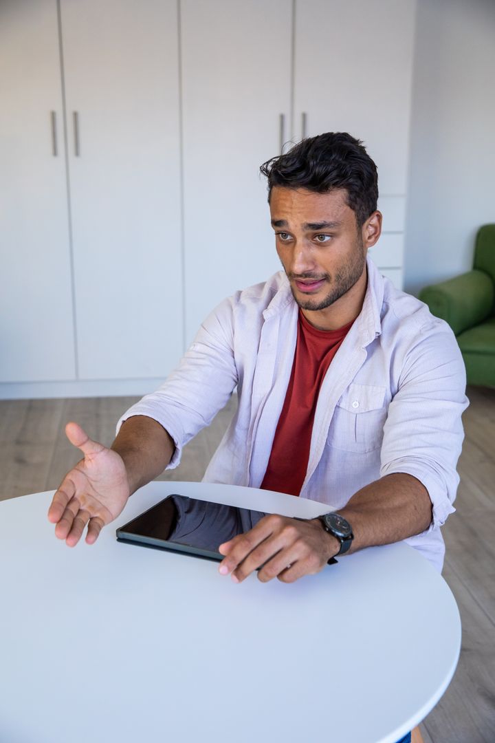 Man in Relaxed Setting Engaging with Tablet Technology