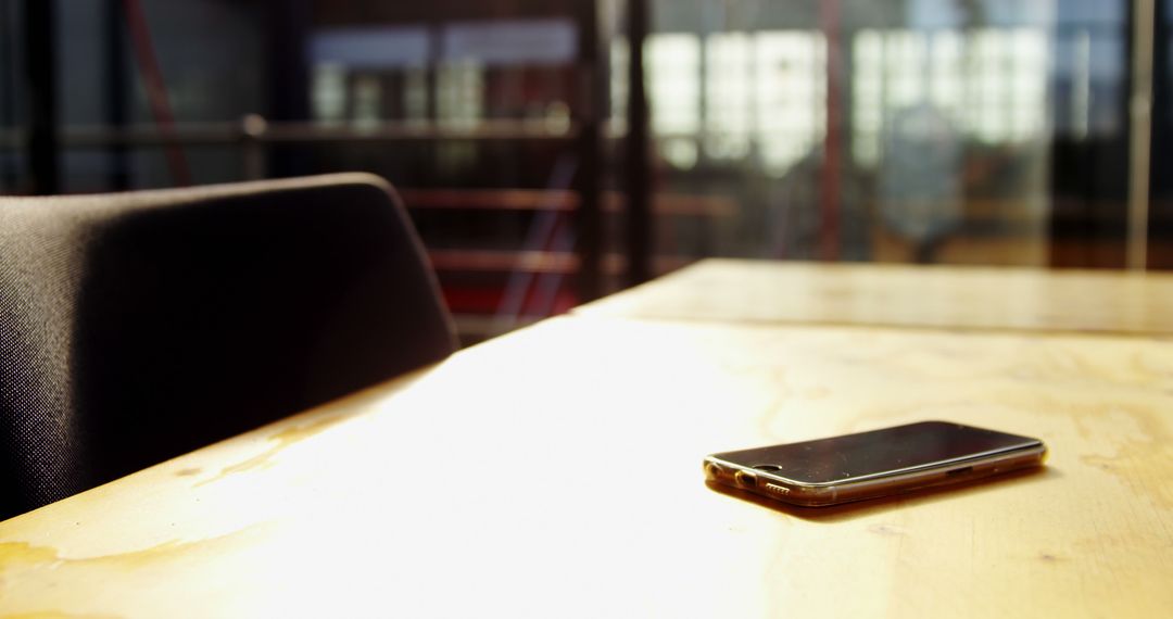 Smartphone on Wooden Table in Sunlit Office Environment - Free Images, Stock Photos and Pictures on Pikwizard.com