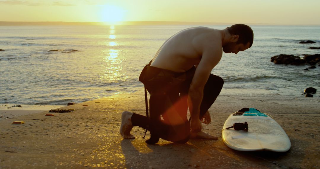 Surfer Preparing Board for Sunset Surf Session on Beach - Free Images, Stock Photos and Pictures on Pikwizard.com