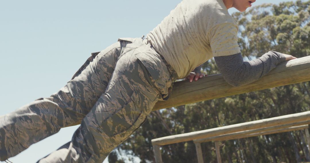 Female Soldier on Obstacle Course Challenge During Sunny Day