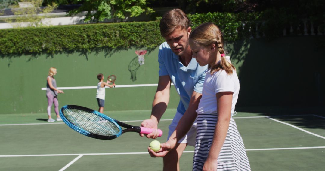 Tennis coach instructing young girl on court - Free Images, Stock Photos and Pictures on Pikwizard.com