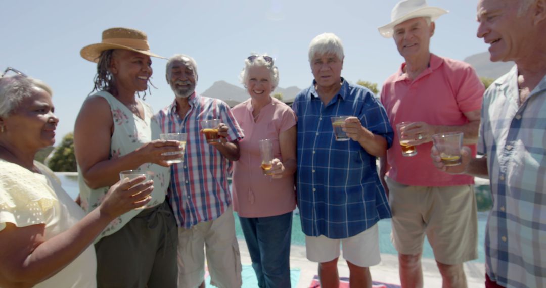 Happy Seniors Toasting by Poolside on Sunny Day - Free Images, Stock Photos and Pictures on Pikwizard.com