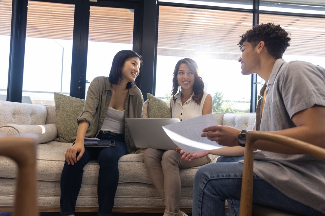 Diverse Professionals Collaborating on Sofa with Technology