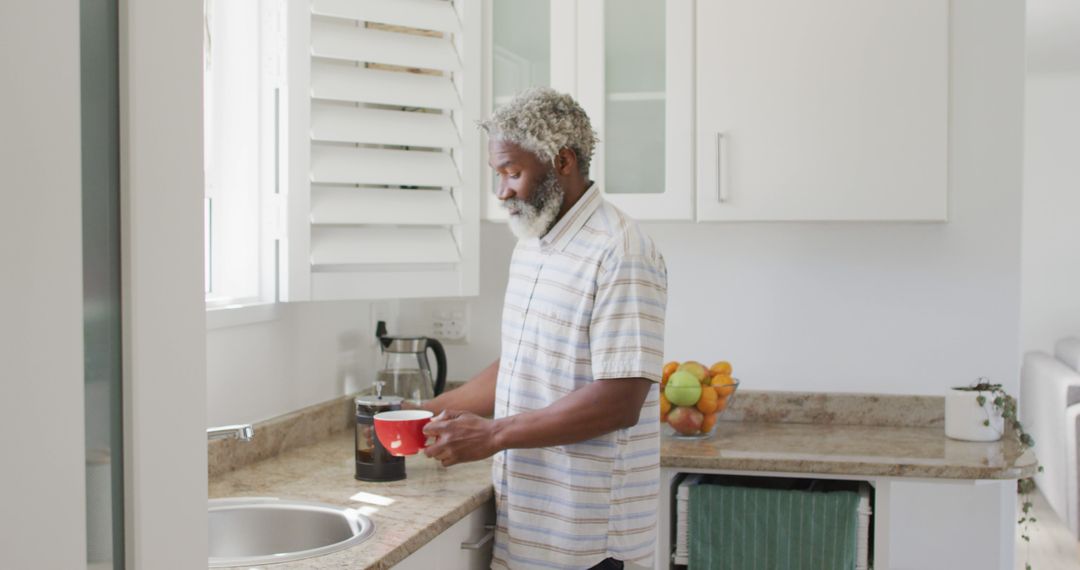 Happy senior man enjoying morning coffee in modern kitchen - Free Images, Stock Photos and Pictures on Pikwizard.com