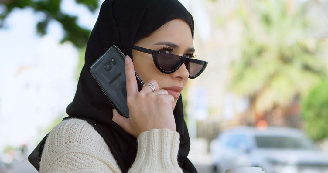 Confident Woman in Hijab Talking on Smartphone Outdoors - Free Images, Stock Photos and Pictures on Pikwizard.com