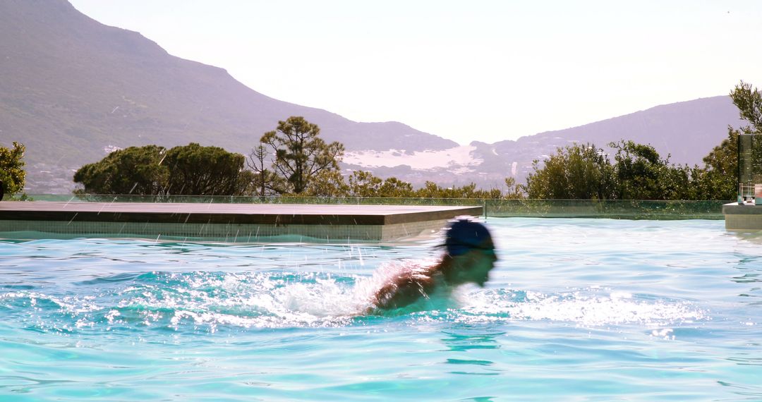 Man Swimming in Outdoor Pool with Scenic Mountain View - Free Images, Stock Photos and Pictures on Pikwizard.com