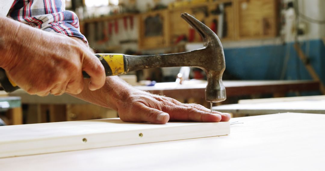 Carpenter Hammering Nail into Wood in Workshop - Free Images, Stock Photos and Pictures on Pikwizard.com