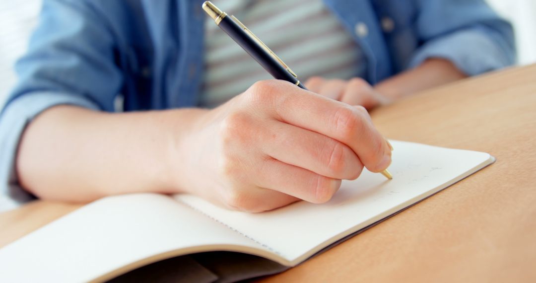 Person Writing in Notebook at Wooden Desk - Free Images, Stock Photos and Pictures on Pikwizard.com