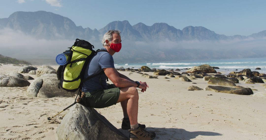 Senior Explorer Resting on Beach With Backpack and Mask