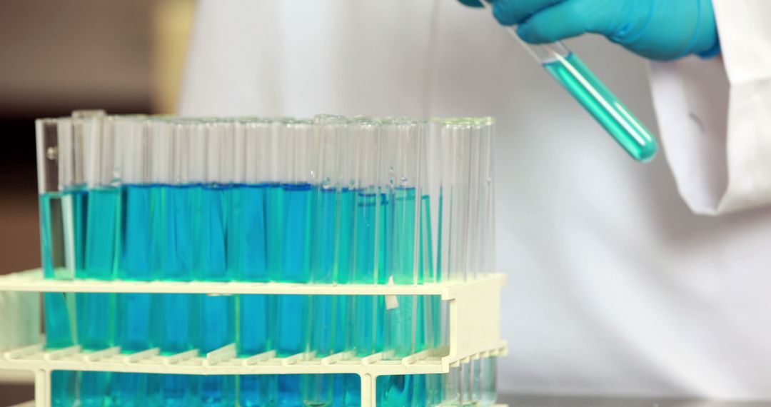 Scientist Handling Test Tubes with Blue Liquid in Laboratory - Free Images, Stock Photos and Pictures on Pikwizard.com