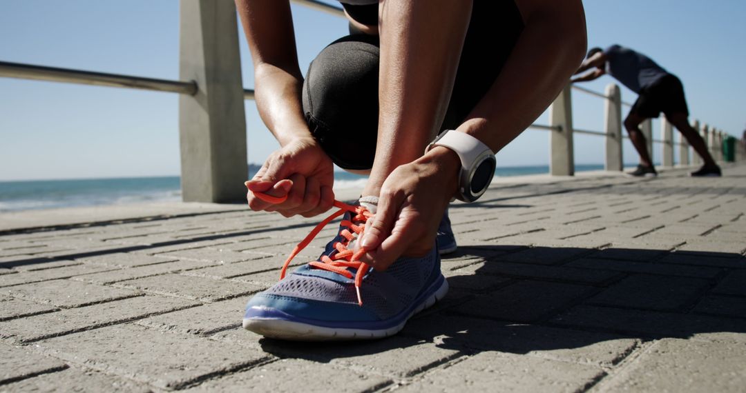Runner Tying Laces on Seaside Promenade for Safe Jog