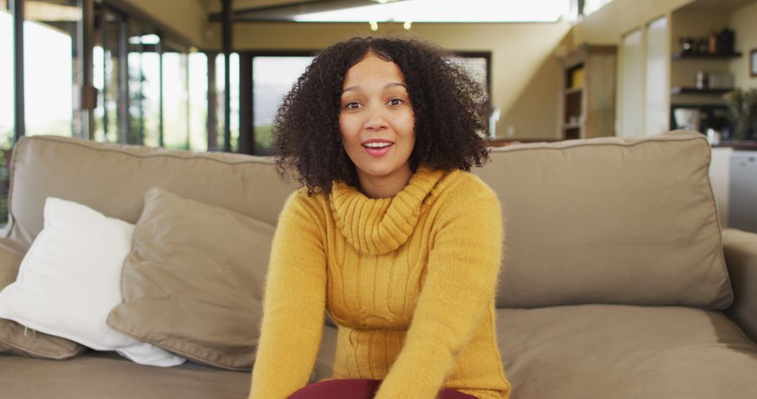 Smiling Woman Sitting on Sofa at Home - Free Images, Stock Photos and Pictures on Pikwizard.com