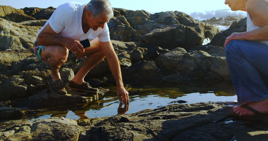 Senior Couple Exploring Rock Pool by the Sea