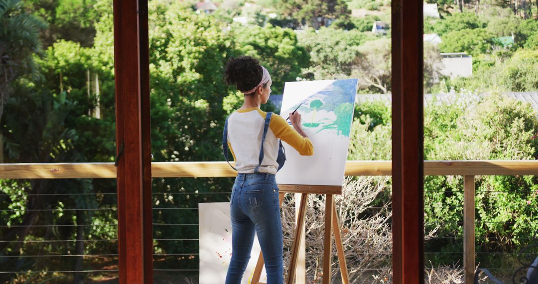 Young Artist Painting on Balcony With Scenic Forest View - Free Images, Stock Photos and Pictures on Pikwizard.com