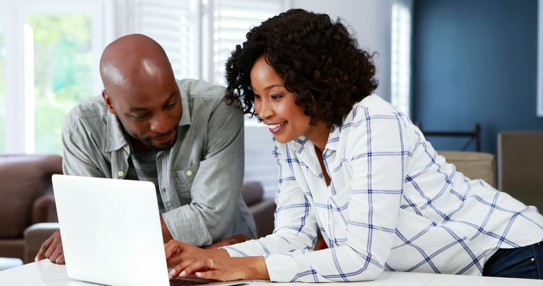 Couple Collaborating on Laptop for Household Tasks