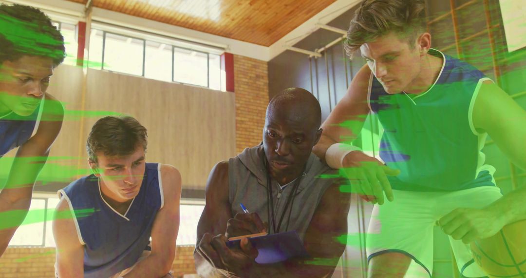 Basketball Coach Strategizing with Team in Energetic Gym