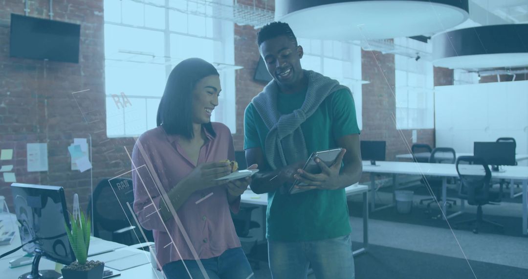 Coworkers Collaborating with Technology in Modern Open-Plan Office