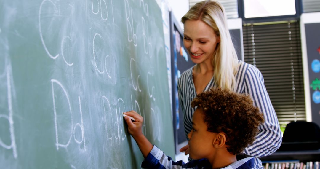 Teacher Helping Student Write Letters on Chalkboard - Free Images, Stock Photos and Pictures on Pikwizard.com