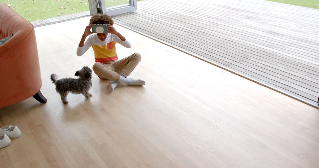 Curly-Haired Boy Interacting with VR Headset and Curious Dog
