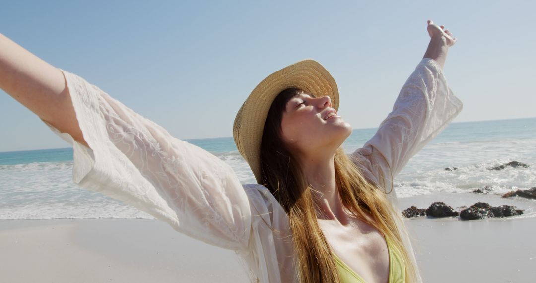 Young Woman Enjoying Beach Day with Open Arms in Sunlight - Free Images, Stock Photos and Pictures on Pikwizard.com