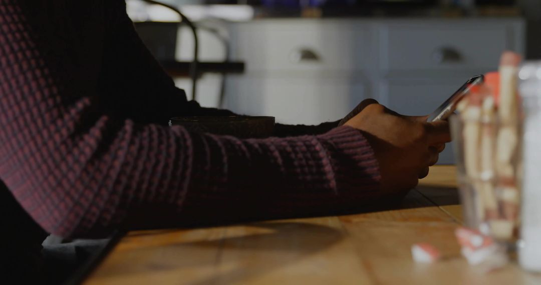 Person Using Smartphone in Casual Cafe Setting