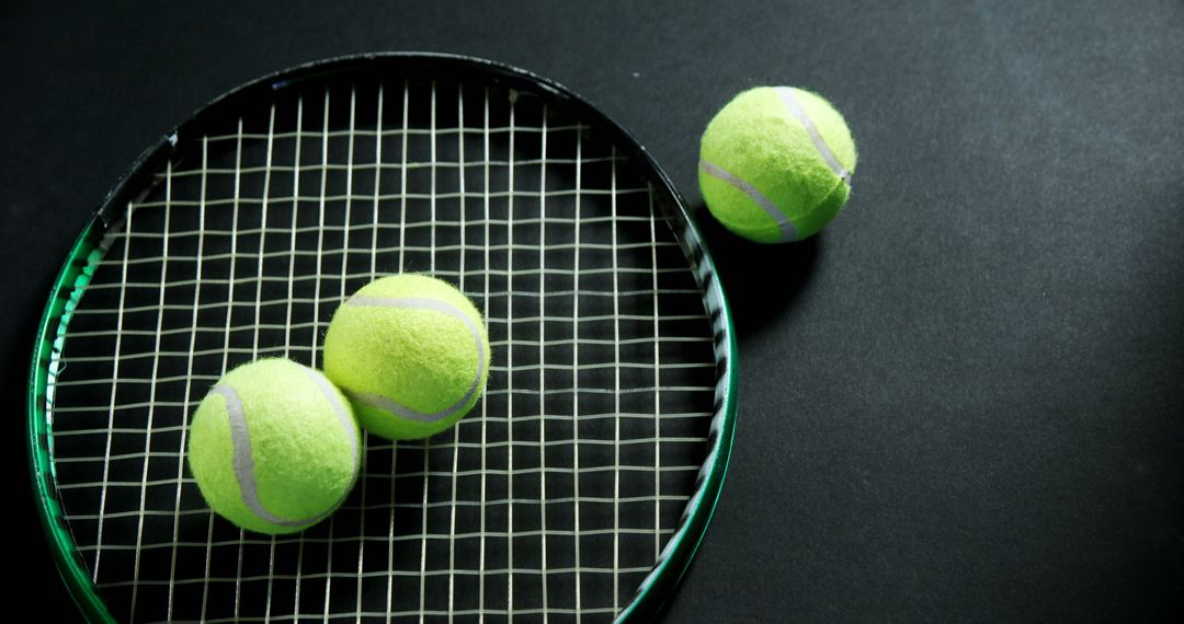 Close-Up View of Tennis Balls on Stringed Racket