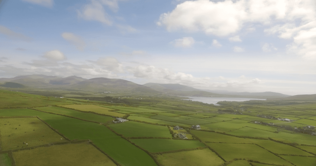 Aerial View of Lush Green Farm Landscape with Blue Sky
