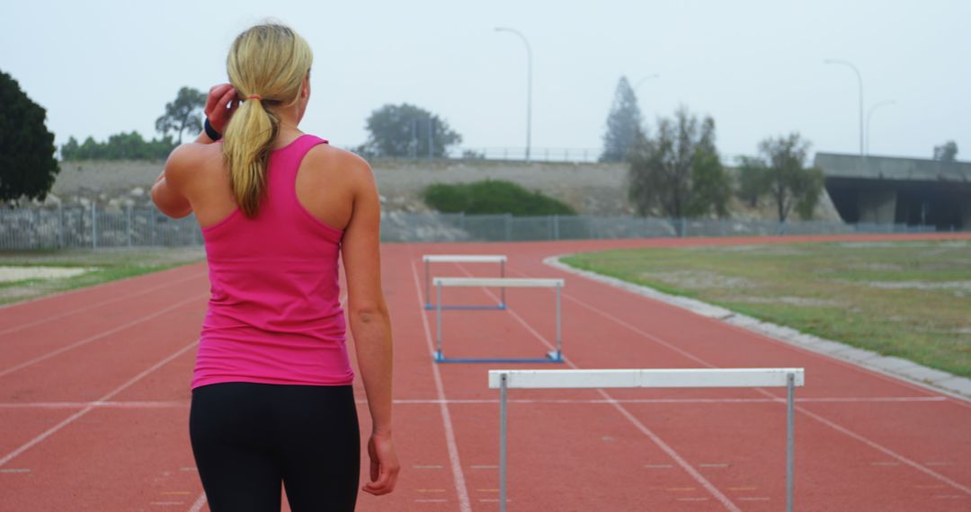 Female Athlete Training on Track with Hurdles - Free Images, Stock Photos and Pictures on Pikwizard.com