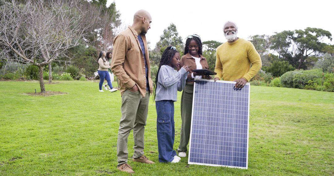 Multigenerational family exploring solar energy in park while using tablet for learning