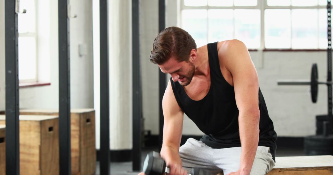 Man lifting dumbbell during workout in gym - Free Images, Stock Photos and Pictures on Pikwizard.com