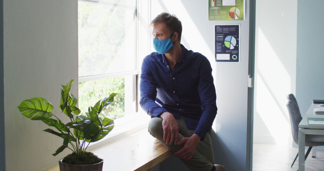 Man Contemplating While Wearing Mask in Modern Office