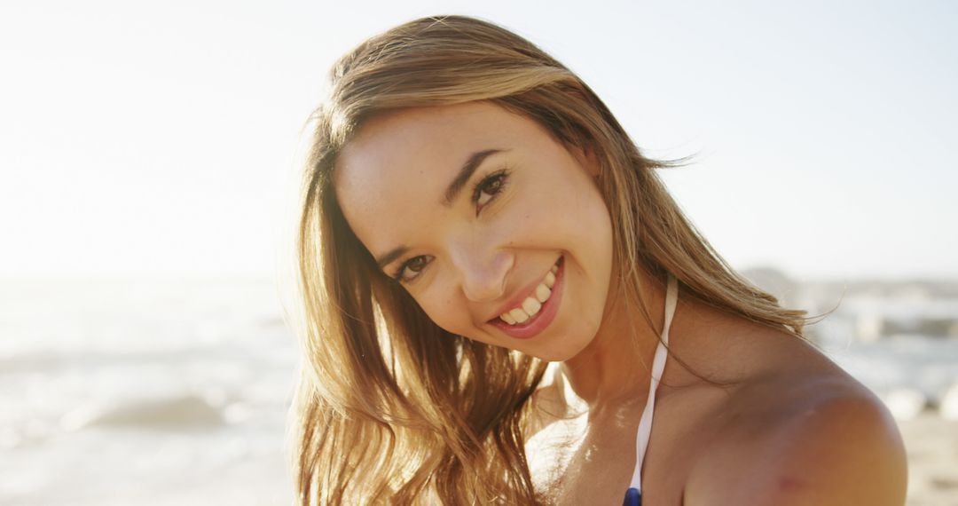 Smiling Woman Enjoying Sunlight on Beach - Free Images, Stock Photos and Pictures on Pikwizard.com