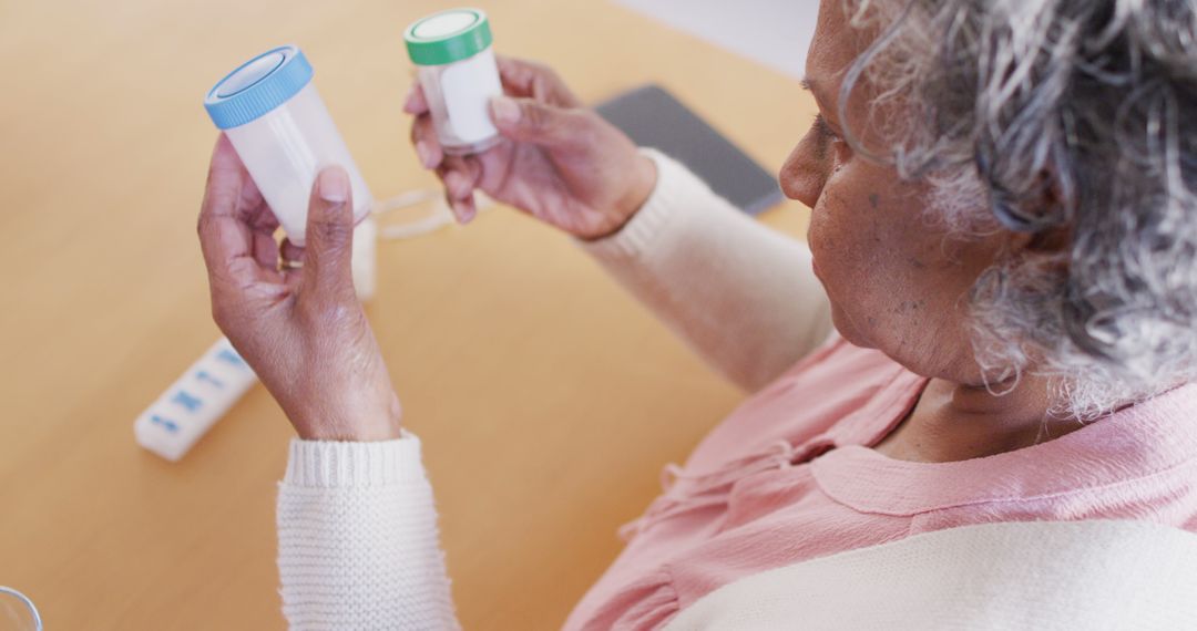 Senior african american woman sitting at table, taking pills - Free Images, Stock Photos and Pictures on Pikwizard.com