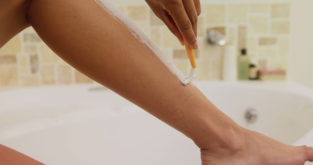 Person Shaving Leg in Bathroom Near Bathtub - Free Images, Stock Photos and Pictures on Pikwizard.com