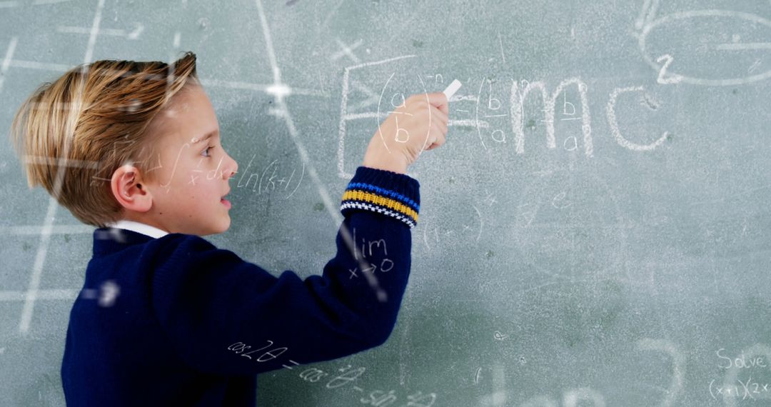 Young Boy Writing Math Formulas on Blackboard