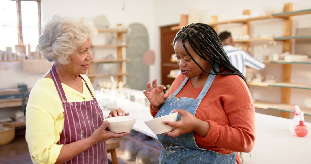 Two Women Discussing Pottery Art in Workshop - Free Images, Stock Photos and Pictures on Pikwizard.com