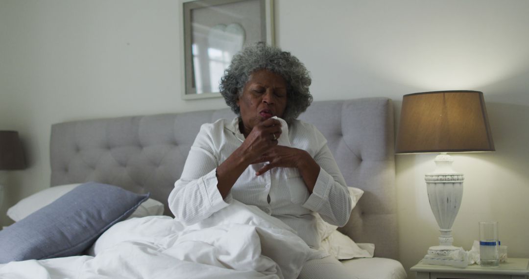 Senior African American Woman Coughing in Bed in Her Bedroom - Free Images, Stock Photos and Pictures on Pikwizard.com