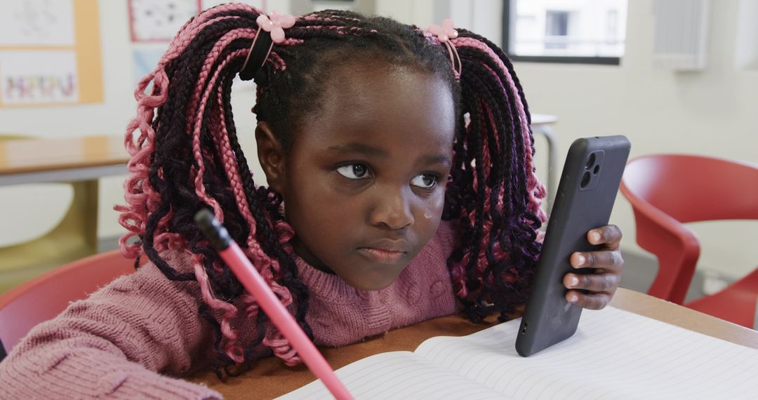 Young Girl in Classroom Using Smartphone While Studying