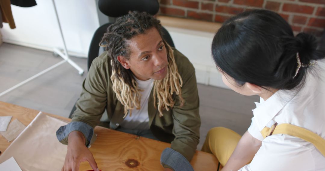 Man with Dreadlocks Consulting with Female Colleague in Modern Office - Free Images, Stock Photos and Pictures on Pikwizard.com