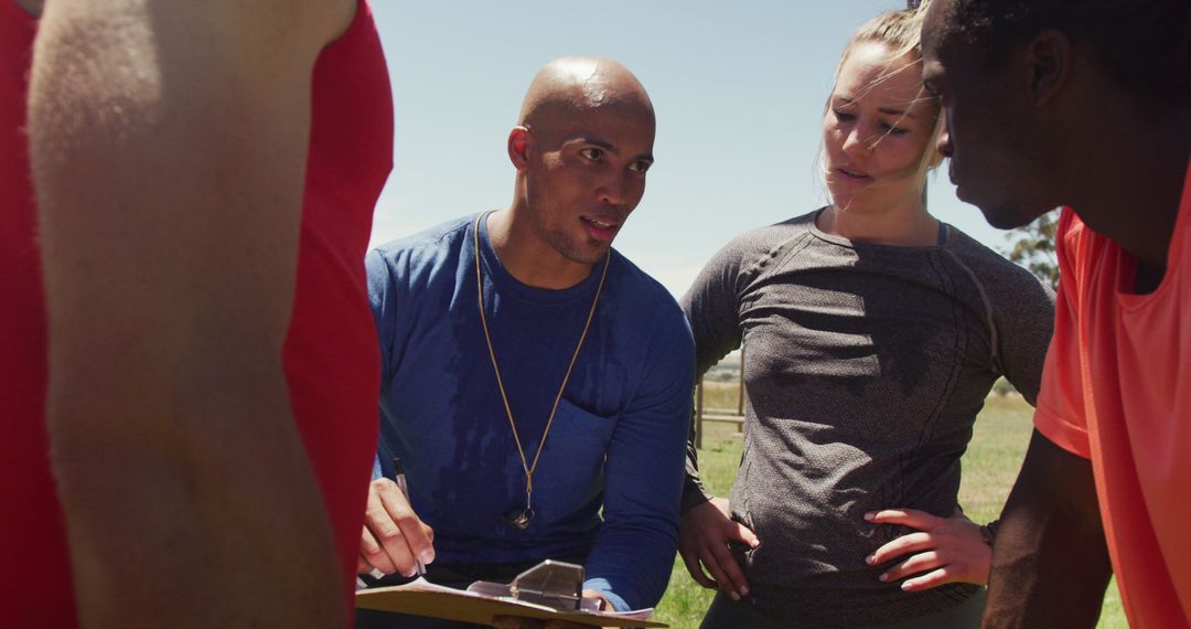 Fit Group and Trainer Discussing Outdoor Workout Strategy
