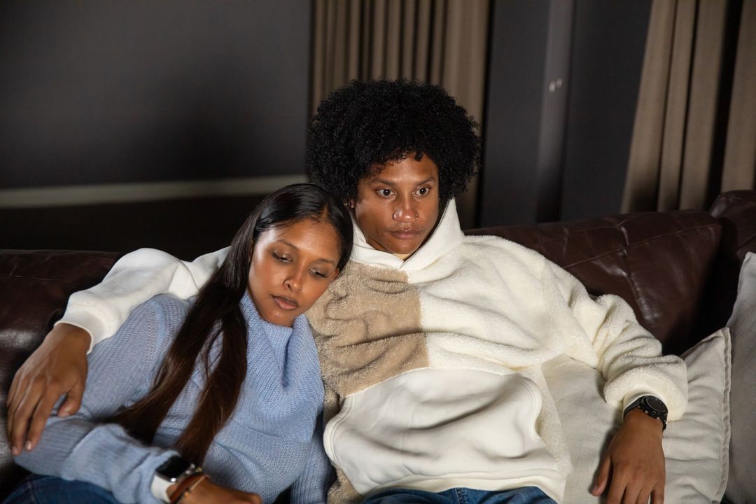 Diverse Couple Relaxing on Leather Couch in Stylish Attire